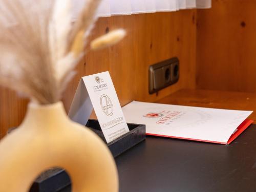 a table with a vase with a card and a box at Gasthaus & Hotel "Zum Boarn" in Rain