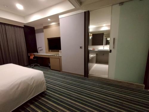 a hotel room with a bed and a bathroom at Urban Hotel33 in Kaohsiung