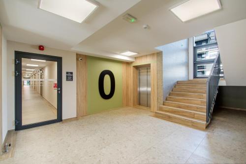 a hallway with stairs and a number on the wall at Klif Apartamenty Posesja Plażowa in Grzybowo