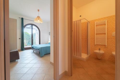 a bedroom with a bed and a bathroom at New Vista Blu Alghero in Alghero