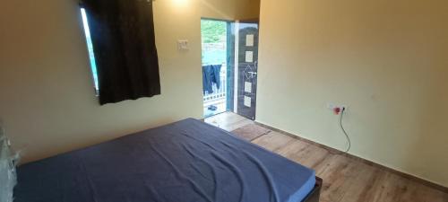 a bedroom with a bed in a room with a window at Happy Hills Karjat in Karjat