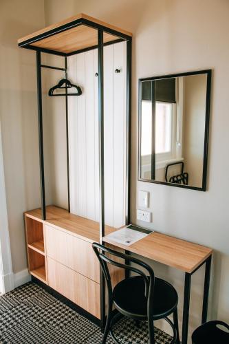 a desk with a mirror and a desk with a chair at Tourist Hotel Narrabri in Narrabri