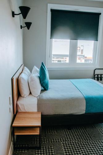a bedroom with a bed with pillows and a window at Tourist Hotel Narrabri in Narrabri