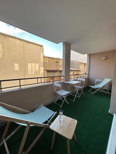Habitación con sillas y mesas en el balcón. en Appartement cosy au cœur de Sète avec balcon détente, en Sète
