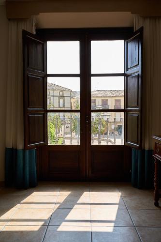 an empty room with a large door and windows at Hotel María de Molina in Úbeda