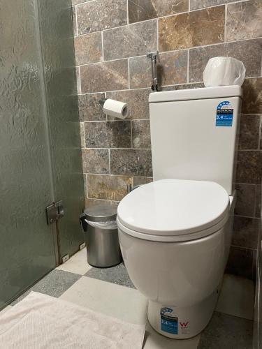 a white toilet in a bathroom with a tile wall at Home in Laverton 19 Minutes to Melbourne CBD in Laverton