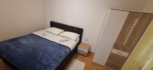 a bedroom with a bed with white pillows and a mirror at Apartments Duje in Bibinje