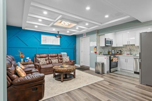 a living room with couches and a table and a kitchen at Private Family Entertainer's Suite in Calgary