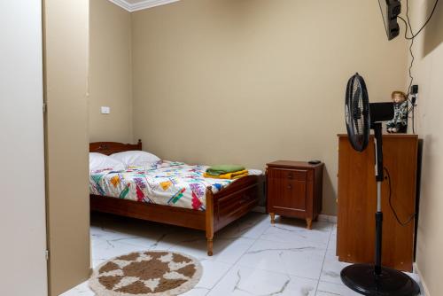 a bedroom with a bed and a dresser and a fan at Traditional Stone House in Vouni, Quiet Stay with Courtyard & BBQ in Vouni