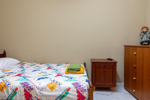 a bedroom with a bed and a wooden dresser at Traditional Stone House in Vouni, Quiet Stay with Courtyard & BBQ in Vouni