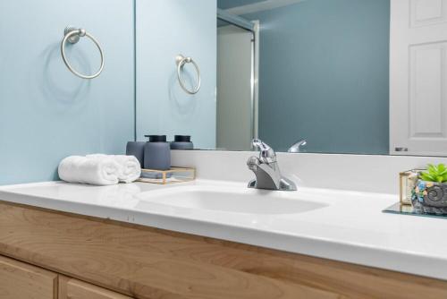 卡尔加里Private Family Entertainer's Suite的浴室里有白色洗手池和镜子