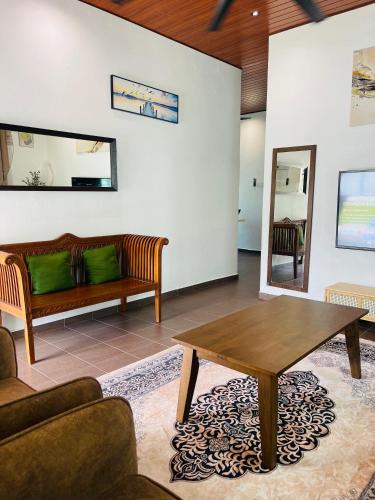 a living room with a couch and a table at Rooma Kichi Private Pool in Pantai Cenang