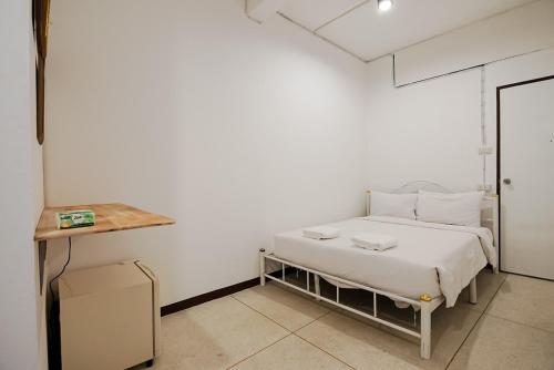 a white bedroom with a bed and a table at xx GO INN Asiatique BKK - โกอินน์ เอเชียทีค เจริญกรุง in Godown