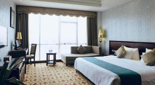 a hotel room with a large bed and a couch at Manhatton Hotel Beihai in Beihai