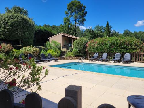 a swimming pool in a garden with chairs around it at GÎTES LES LAUZIÈRES CLIMATISÉS avec PISCINE in Tauriers