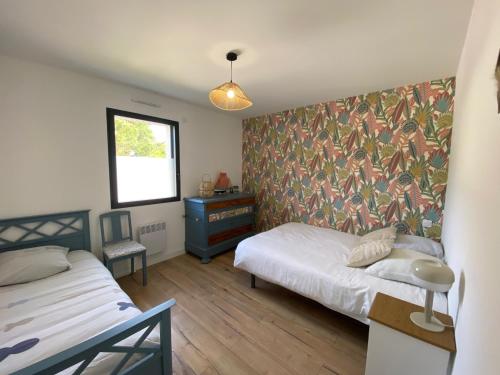 une chambre avec deux lits et un bureau et une fenêtre dans l'établissement Les pieds dans le sable, à Saint-Jean-de-Monts