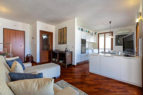 a living room with a couch and a kitchen at La Vela - appartamento in centro - vista mare in Alghero