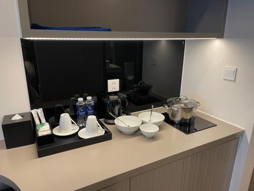 a kitchen counter with bowls and appliances on it at Wyndham Lynn Times Thanh Thủy - Ks khoáng nóng 5 sao in La Phu