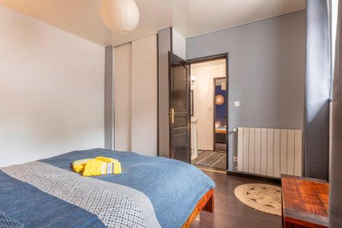 - une chambre avec un lit bleu et un oreiller jaune dans l'établissement Les Vagues Douces - Grande maison - Plage 600m, à Fécamp