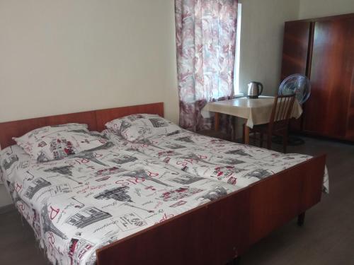 a bedroom with a bed with a comforter on it at Special Guest House in Zugdidi
