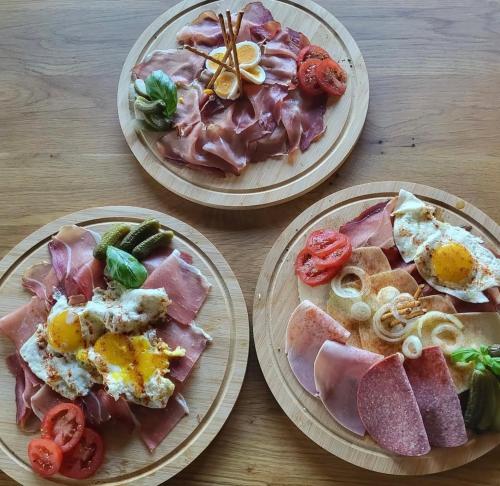 three plates of food on a wooden table at Haus Petra in Stadtkyll