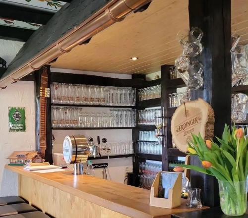 a bar in a restaurant with a counter with glasses at Haus Petra in Stadtkyll