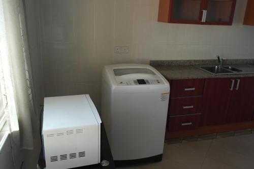 a small kitchen with a refrigerator and a sink at Ridge Over Suite in Accra