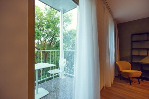 a room with a balcony with a table and a chair at LeonArt Living 42 in Graz
