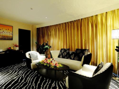 a living room with a couch and two chairs at Kunming Long Way Hotel in Kunming