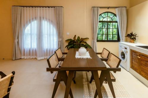 a dining room with a wooden table and chairs at Indie Beach Bungalows in Ko Chang