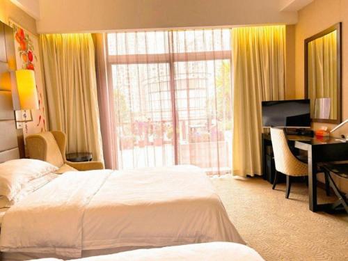 a hotel room with two beds and a desk and a window at Jiaxin Conifer Hotel Shunde in Shunde