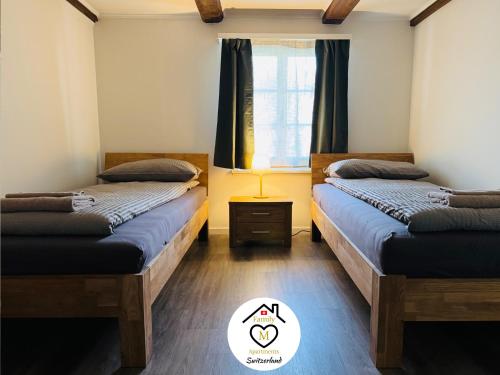 two beds in a room with a window at Family M Apartments 16-17-18 in Sempach