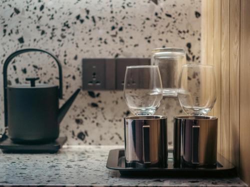 two wine glasses sitting on top of a counter at Shō Hotel BreakX in Jelutong