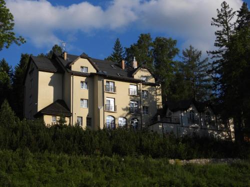 a large house on a hill with trees at Hotel Vivaldi in Karpacz