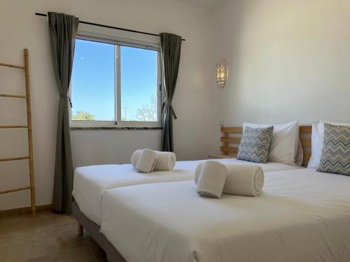 2 weiße Betten in einem Zimmer mit Fenster in der Unterkunft Boutique holiday home "Casa da vida doce" I Private, quiet & stylish I Pool, garden, sea view I For families, friends & couples in Lagoa