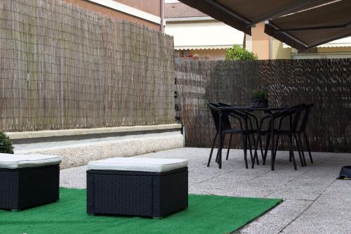 a patio with a table and chairs on a green rug at Sky House in Piacenza