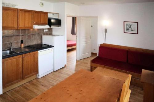 - un salon avec une cuisine et une table dans une pièce dans l'établissement Les Chalets De Bois Mean - Appartement 3 pièces pour 8 personnes Les Orres 1800 MAE-0964, aux Orres