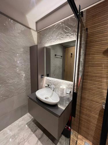 a bathroom with a sink and a mirror at The Diamond In City Luxury Suites By ZENORA Living in Accra