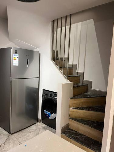 a kitchen with a stainless steel refrigerator and stairs at The Diamond In City Luxury Suites By ZENORA Living in Accra