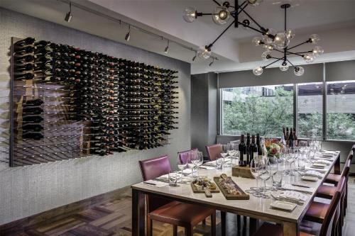 a dining room with a long table and a wall of wine bottles at Hyatt Centric Chicago Magnificent Mile in Chicago