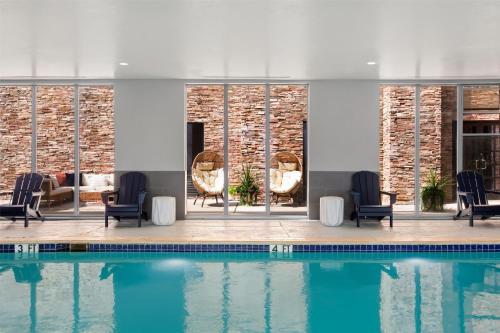 a swimming pool with chairs and a table at Hampton Inn & Suites Dallas-Arlington North-Entertainment District in Arlington