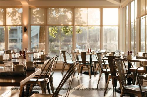 a dining room with tables and chairs and windows at Hyatt Regency Lost Pines Resort and Spa in Cedar Creek