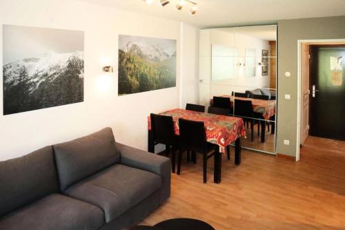 un salon avec un canapé et une table avec des chaises dans l'établissement Residence La Combe D Or - Appartement en résidence de standing MAE-3904, à Le Mélézet