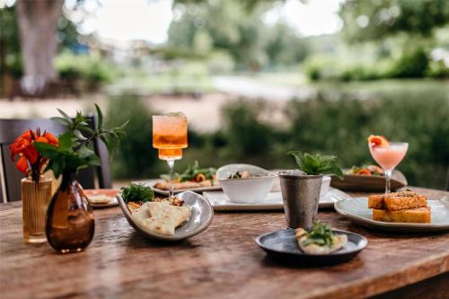 a wooden table topped with plates of food and drinks at Hyatt Regency Lost Pines Resort and Spa in Cedar Creek