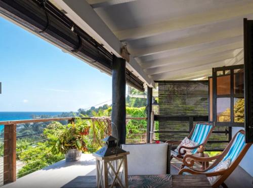 a porch with chairs and a view of the ocean at Vi Miles Lodge in Mahe