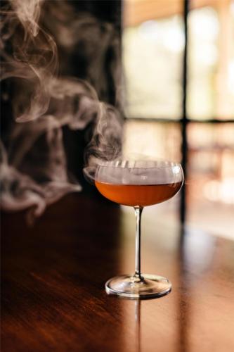 a glass filled with smoke on a wooden table at Hyatt Regency Lost Pines Resort and Spa in Cedar Creek