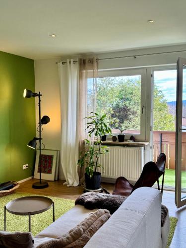 a living room with a couch and a large window at Ferienwohnung Fichtel-STEIN in Fichtelberg