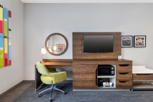 a room with a desk with a television and a chair at Hampton Inn Las Vegas/North Speedway in Las Vegas
