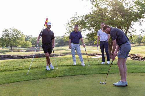 a group of men playing golf on a golf course at Hyatt Regency Lost Pines Resort and Spa in Cedar Creek