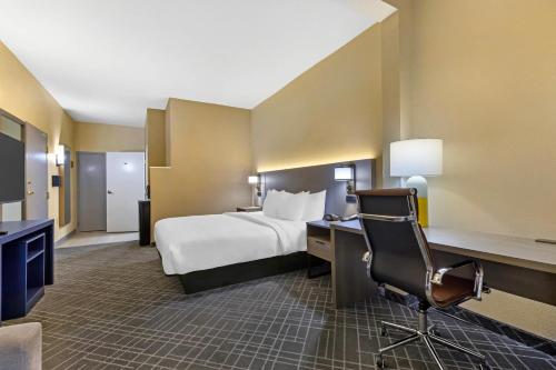 a hotel room with a bed and a desk and a chair at Comfort Suites Hanes Mall in Winston-Salem